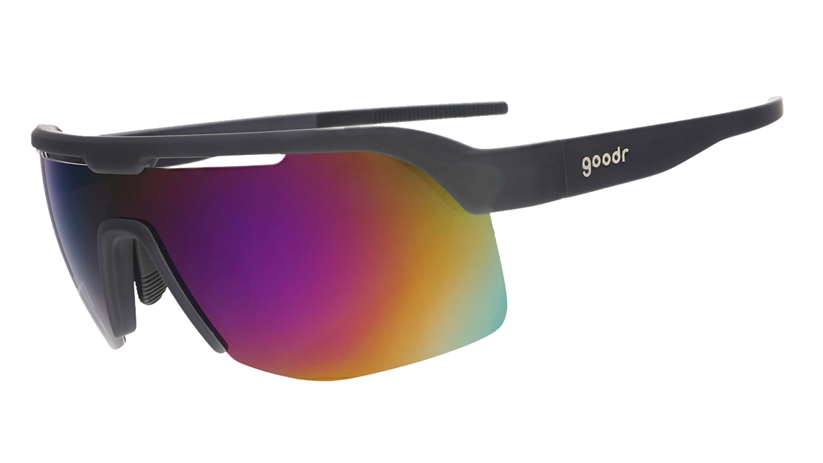 Three-quarter angle view of black shield sunnies with purple reflective wrap lenses tilted down on a white background.