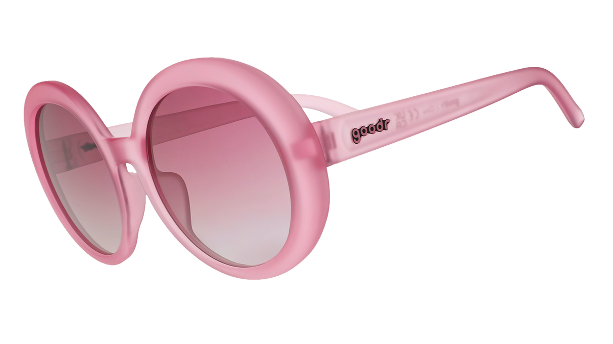 Three-quarter angle view of oversized, round, translucent pink Mood G sunglasses with purple gradient lenses.