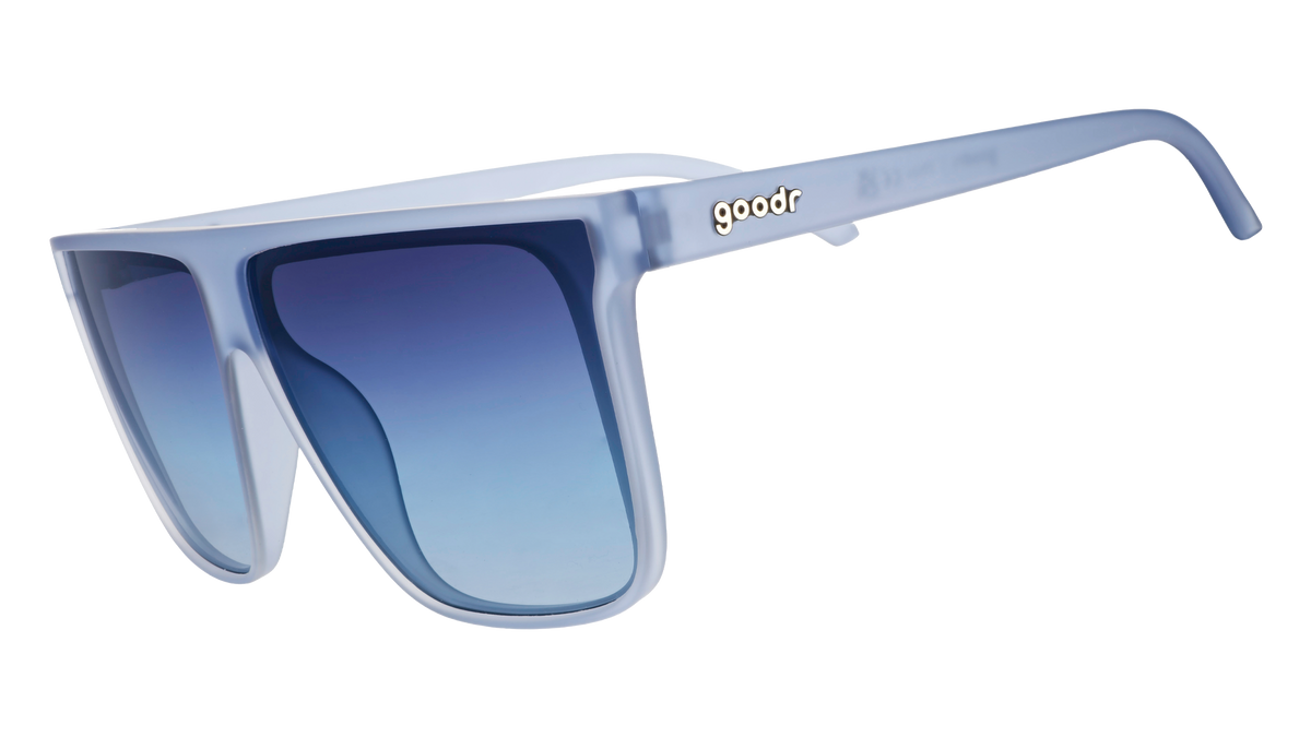 Three-quarter angle view of oversized, dusty blue Fly G sunglasses with blue gradient lenses.