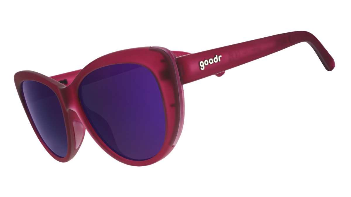 Three-quarter angle view of translucent purple cat-eye sunglasses with purple reflective lenses.