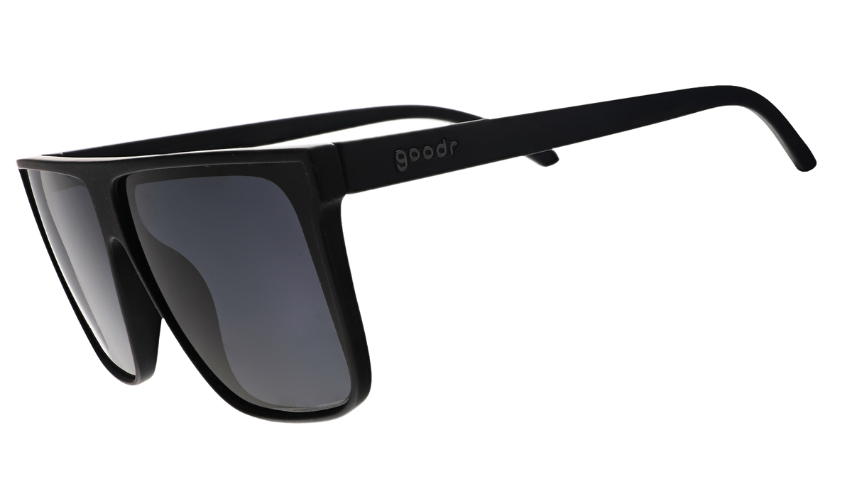 Three-quarter view of black wide-fit, oversized flat-top sunglasses with black non-reflective lenses.
