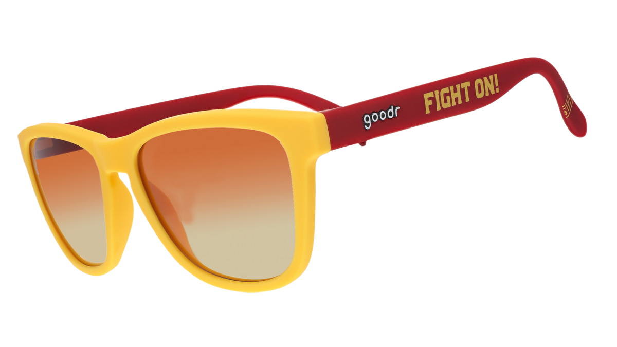 A pair of sunglasses with bright yellow frames and red arms, featuring the words "Fight On!" in bold yellow text on the side. The lenses have a gradient from orange to light.