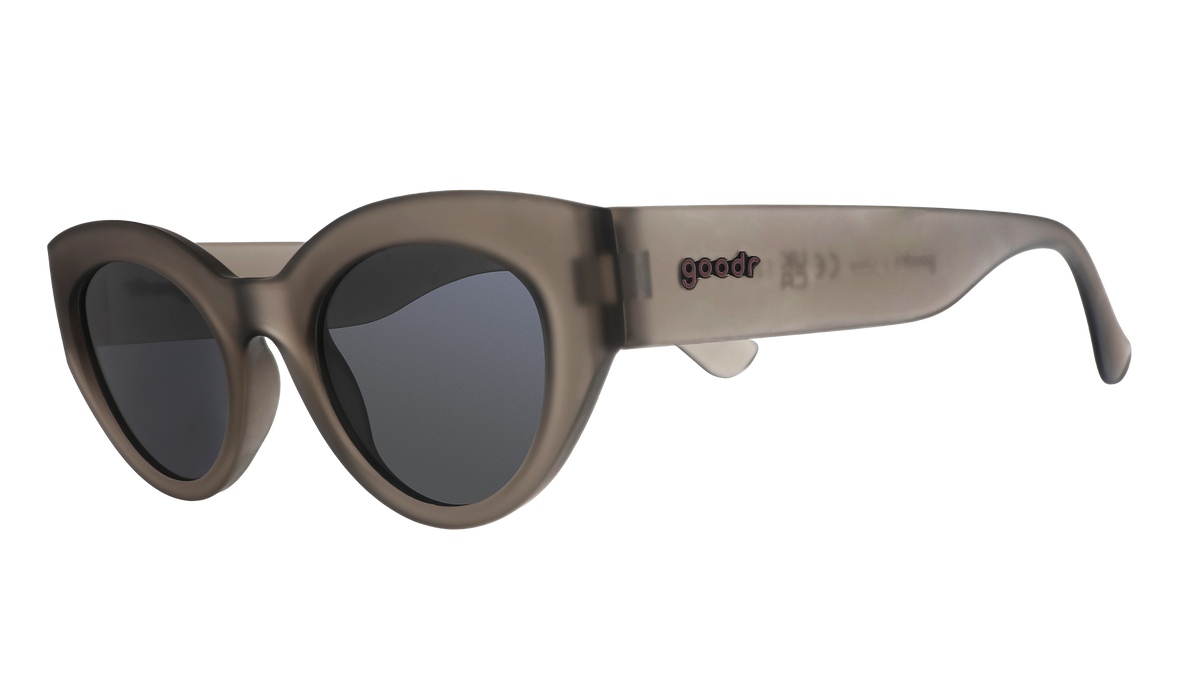 Three-quarter angle view of translucent dark gray, retro-inspired angled cat-eye sunglasses with black non-reflective lenses.