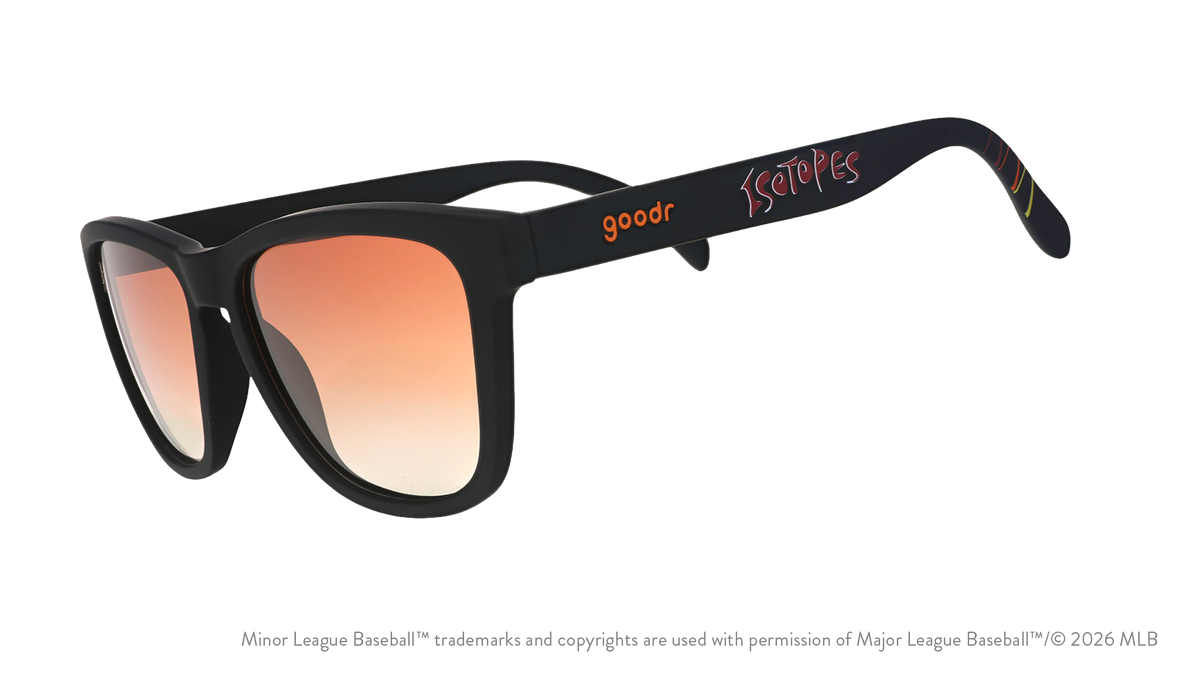 Three-quarter angle view of shades tilted down. Black frames w/ Isotopes + logo on temples. Amber reflective lenses.