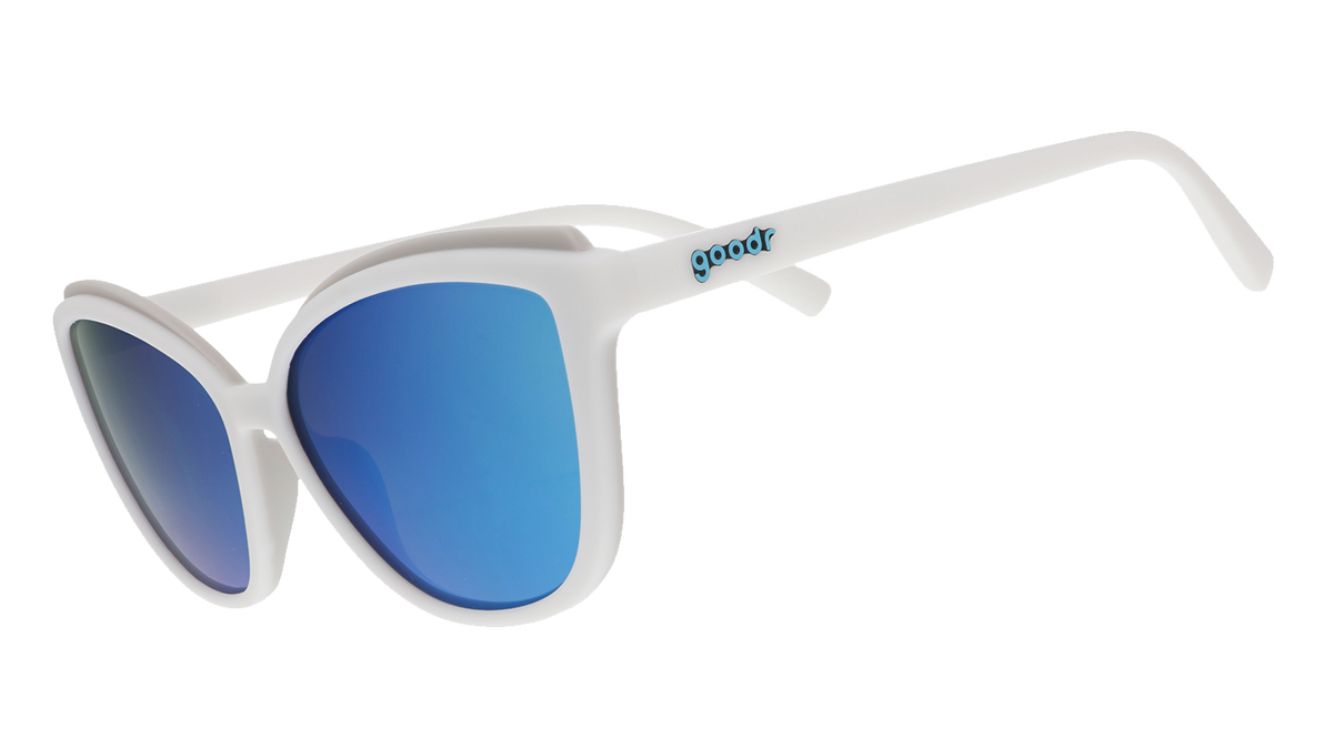 White cat-eye sunglasses with light blue mirrored lenses on a blue patterned background.