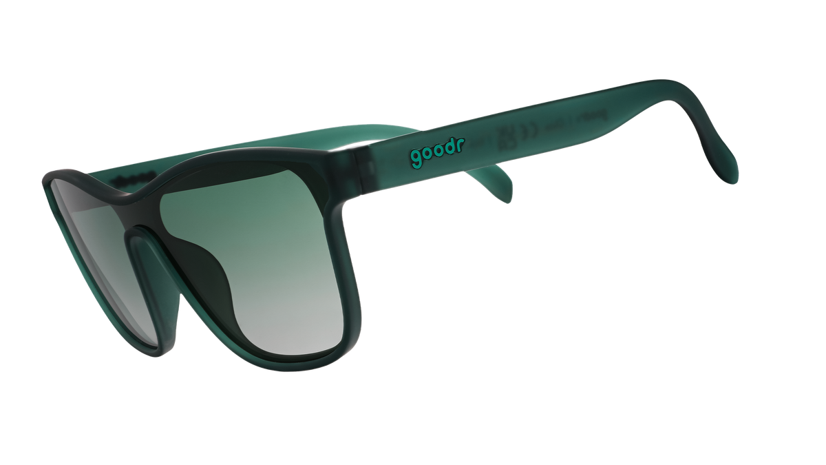 Three-quarter angle view of translucent teal one-lens sunglasses with green gradient lenses.