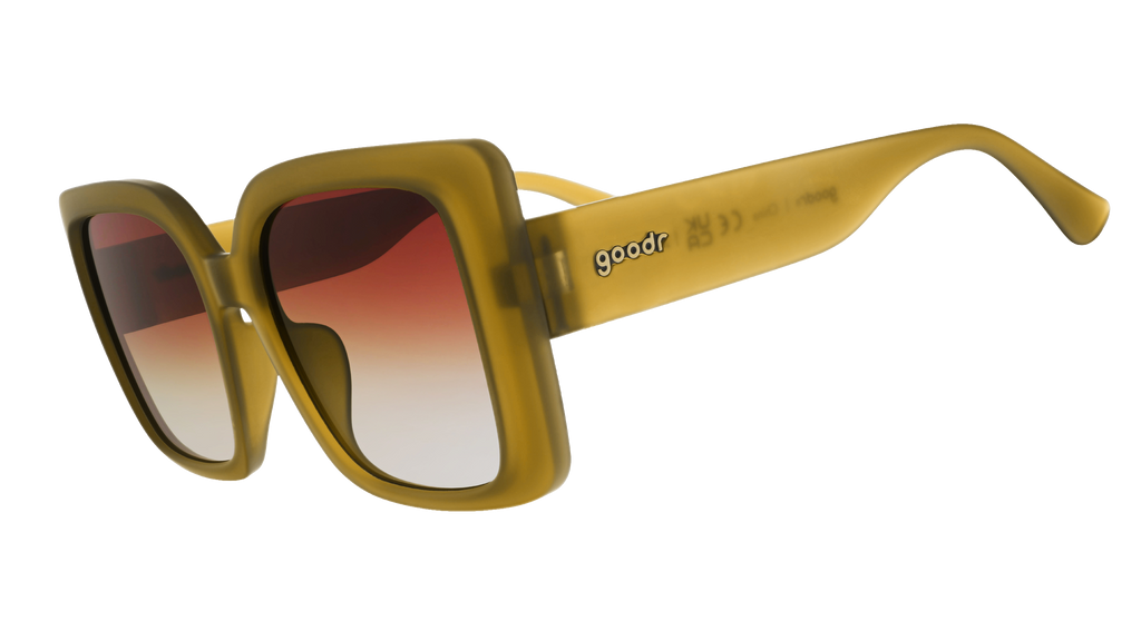 Three-quarter-angle view of translucent, oversized square Amp Gs in a dusted-ochre hue with brown-gray gradient lenses.