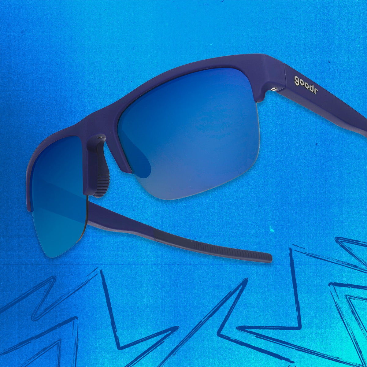 Three-quarter angle view of navy blue shades w/ half-rim frames+blue gradient lenses tilted up on a blue background.