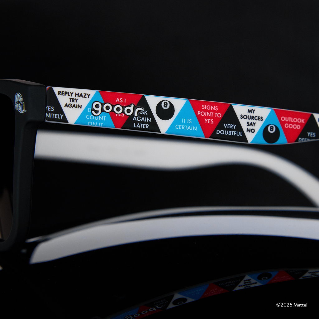 Close-up view of a sunglasses arm featuring classic Magic 8 Ball responses in a red, white, blue, and black triangle design.