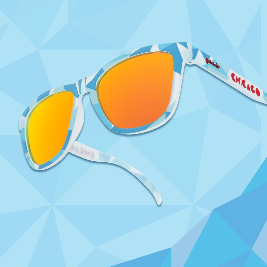 Translucent blue, geometric-patterned sunglasses against a blue geometric background.