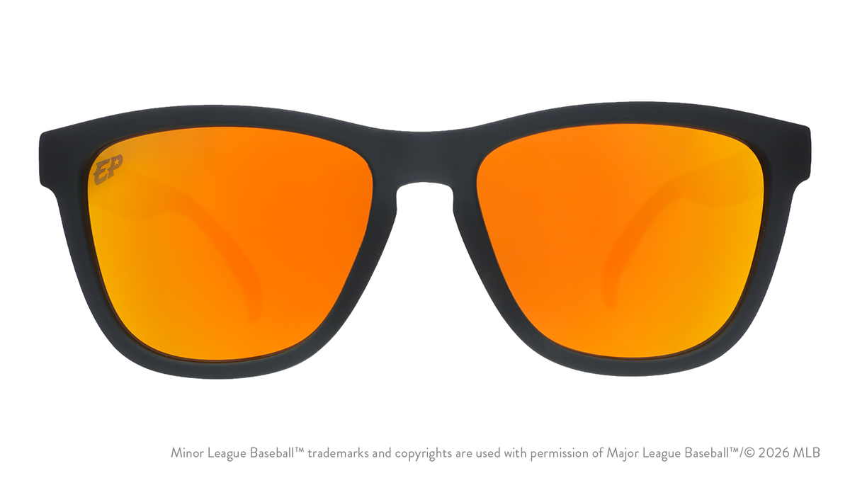 Front view of sunglasses. Dark gray front frame. Amber reflective lenses. Chihuahuas logo etching in top corner of lens.
