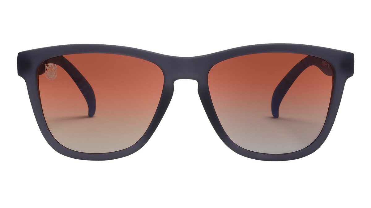 Front view of Major League Soccer San Diego FC sunglasses. Dark gray front frame. Orange gold gradient lenses.