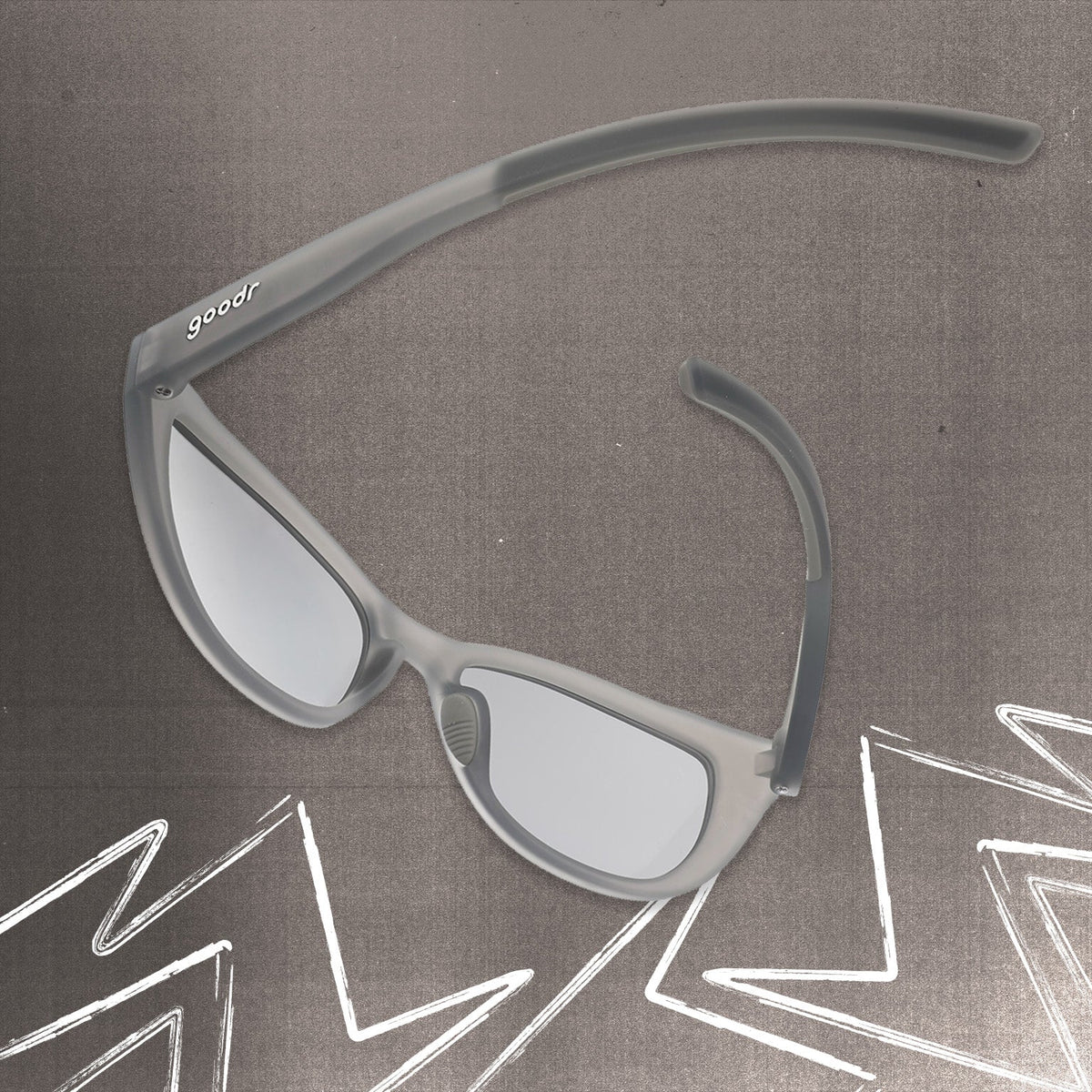 Back view of gray cat eye shades with chrome lenses tilted down on a gray background.