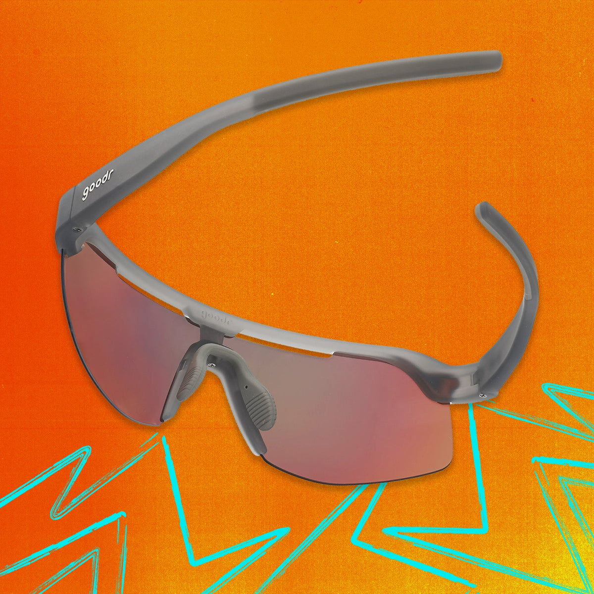 Back view of gray shield sunglasses with orange reflective wrap lenses tilted down on an orange background.