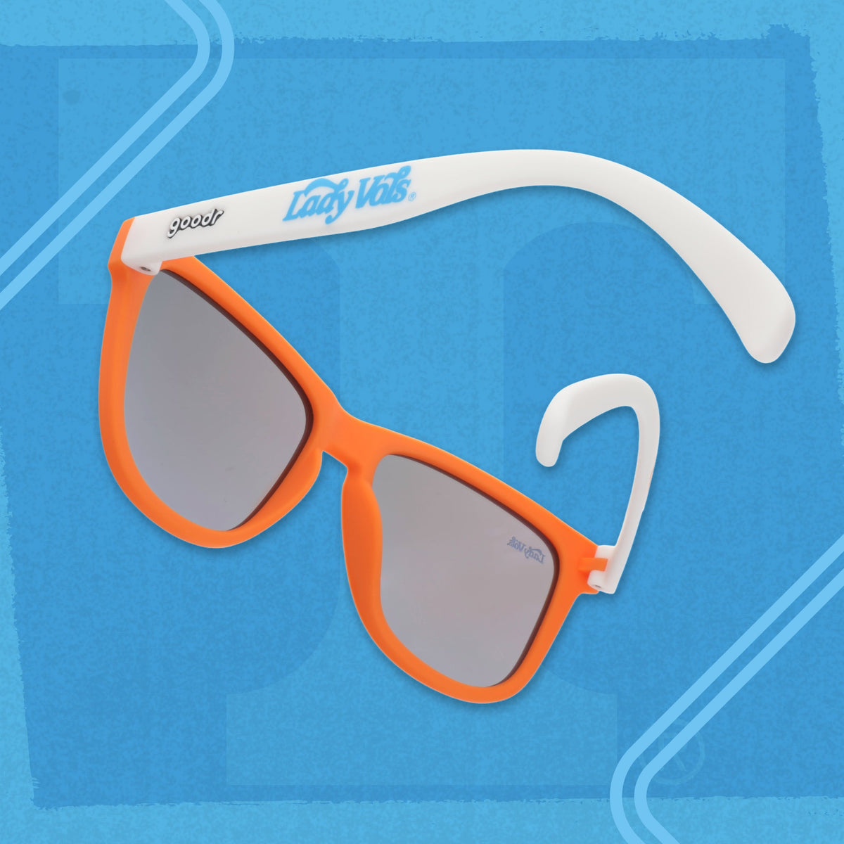 Angled view of Lady Vols goodr sunglasses with an orange frame, white arms, and blue reflective lenses.