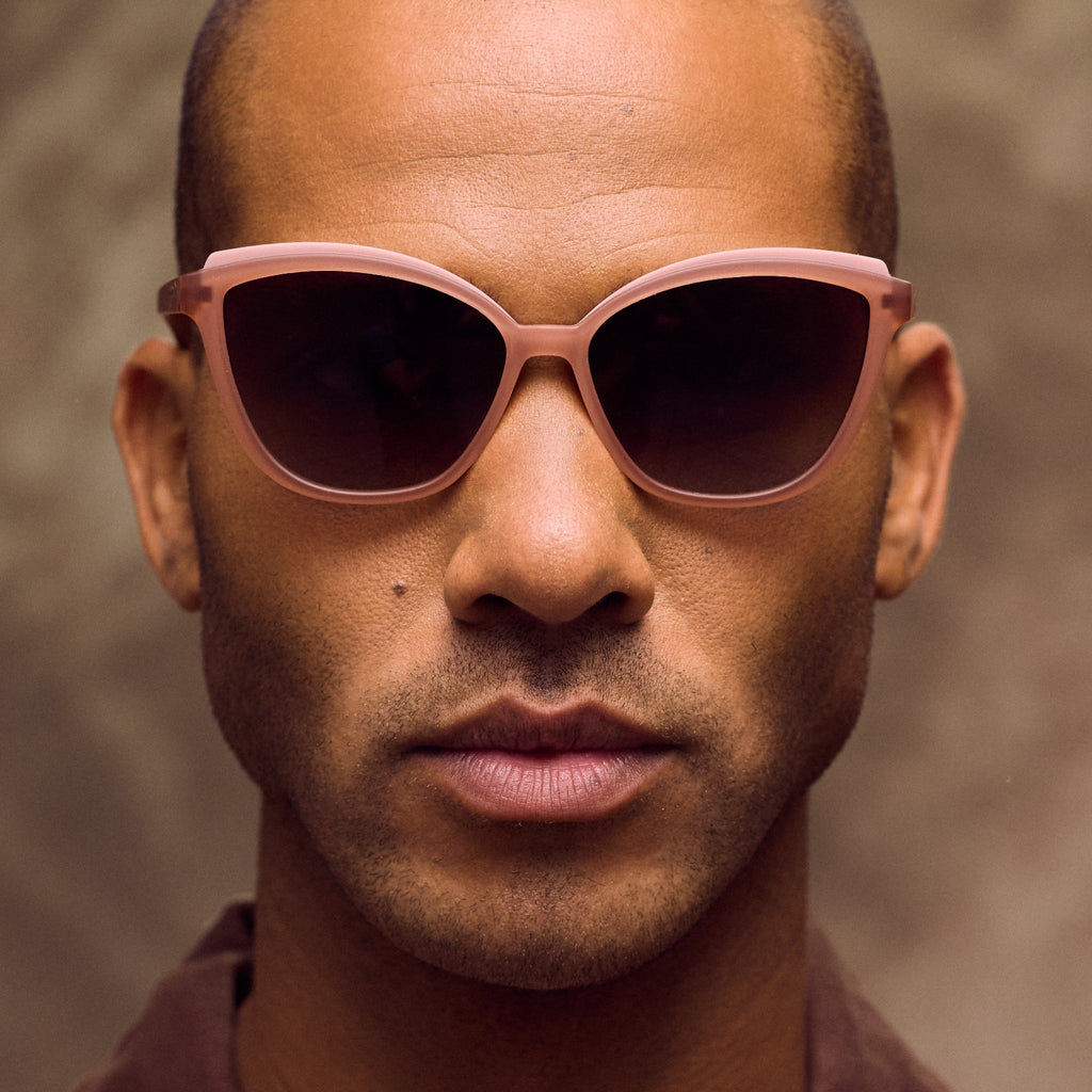 Man wearing brown sunglasses against a brown background